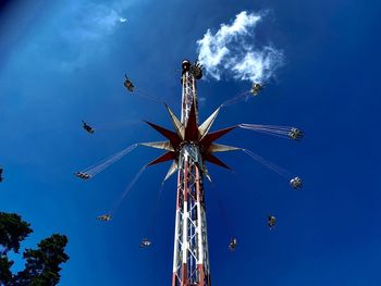 Low angle view of chain swing ride against blue sky