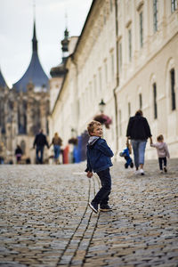 People walking on street amidst buildings in city