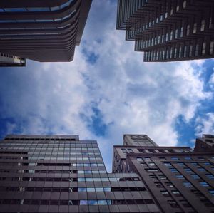 Low angle view of buildings against cloudy sky