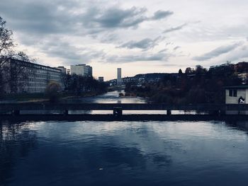 River by cityscape against sky