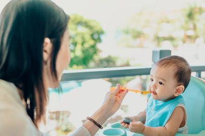 Close-up of woman feeding son