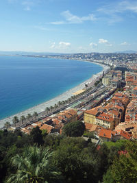 High angle view of town by sea against sky