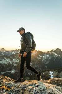 Active man on the move traversing high mountain pass carrying backpack