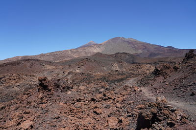 Scenic view of mountains against clear blue sky