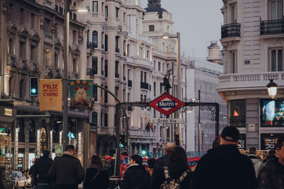 People on street against buildings in city