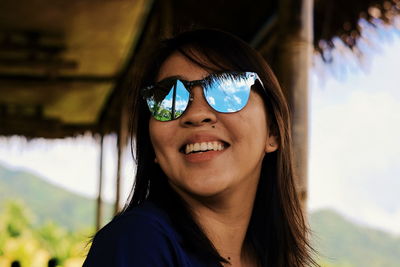 Portrait of smiling young woman wearing sunglasses