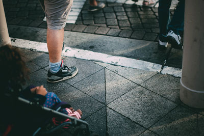 Low section of people standing on sidewalk