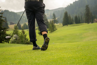 Low section of man standing on golf course