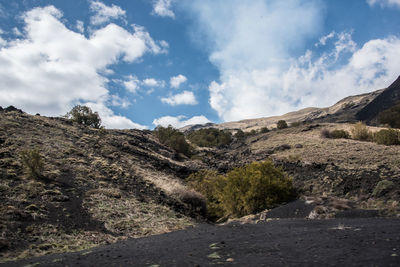 Scenic view of road by mountains against sky