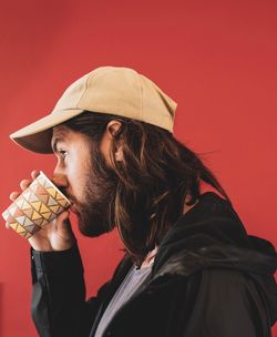 Side view portrait of a man holding red cake