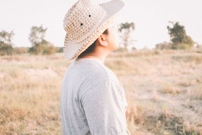 Portrait of man wearing hat standing on field