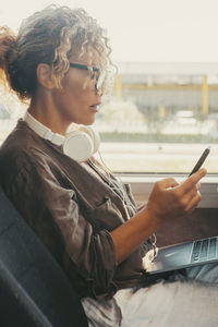 Side view of young woman using laptop while sitting at home