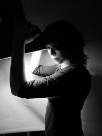 Portrait of a young woman looking away against wall