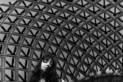 Portrait of woman against patterned ceiling