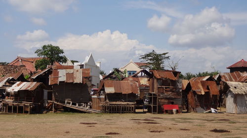 Houses by buildings against sky