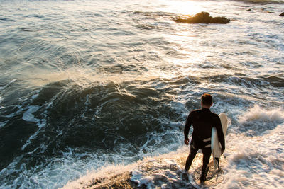 Rear view of man standing on beach