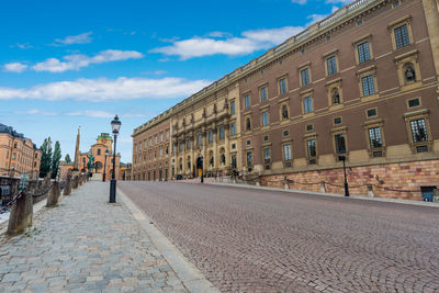 View of city street against cloudy sky