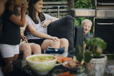 Boy playing with sisters in backyard during dinner party