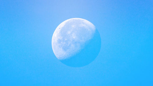 Low angle view of moon against blue sky