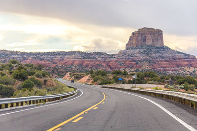 Road leading towards mountains against sky