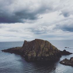 Rock formations by sea against sky