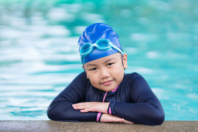 Happy children smiling cute little girl in sunglasses in swimming pool.