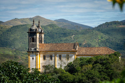 Traditional building by mountains against sky