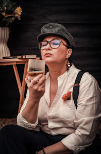 Mid adult woman looking away while sitting indoors 