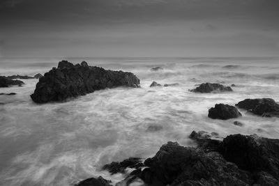 Rocks on sea shore against sky