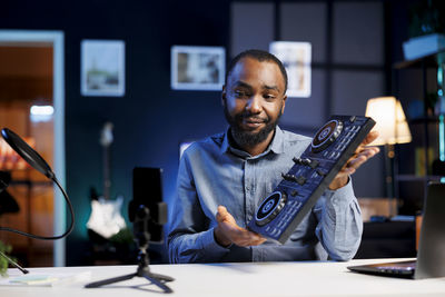 Portrait of young man using mobile phone at home