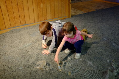 High angle view of siblings painting on floor