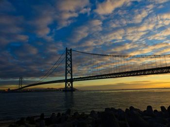 Bridge over sea against sky during sunset