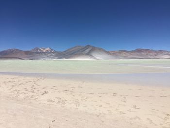 Scenic view of desert against clear blue sky