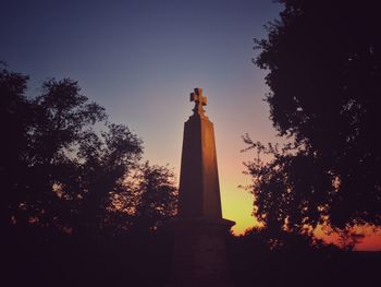 Low angle view of silhouette statue against sky