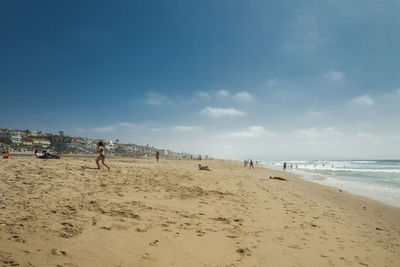 People at beach against sky