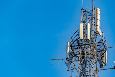 Close up shot of communications tower hosting various antennas and dishes