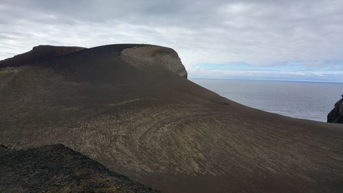 Scenic view of sea and mountains against sky