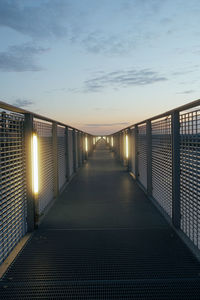 Empty footbridge against sky