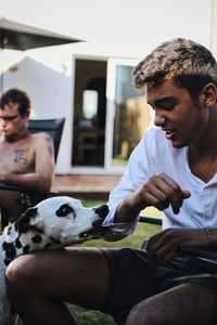 Man playing with dog sitting at home