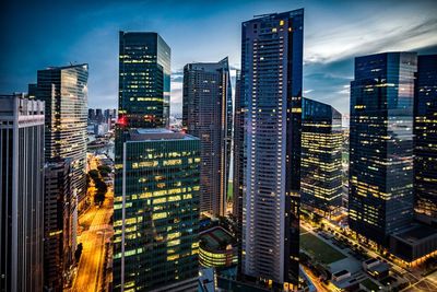 Aerial view of illuminated cityscape against sky at dusk