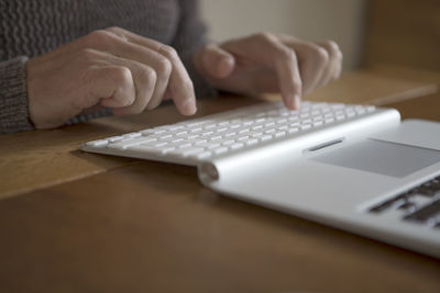Close-up of person using laptop on table