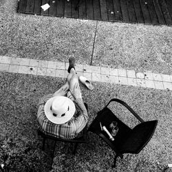 High angle view of person sitting on sidewalk