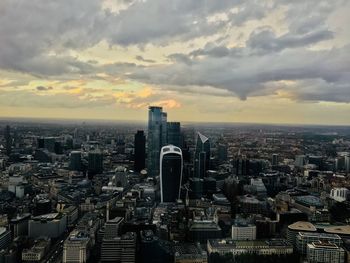 High angle view of buildings in city against cloudy sky
