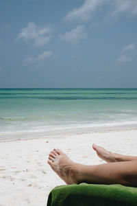 Low section of person relaxing at beach