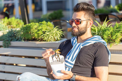 Midsection of man holding ice cream cone outdoors