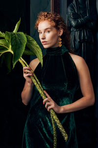 Beautiful young woman holding plant