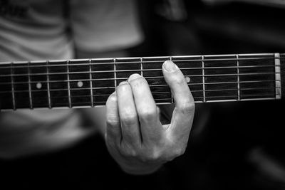 Midsection of man playing guitar