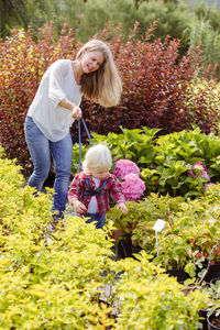 Rear view of women walking on flowering plants