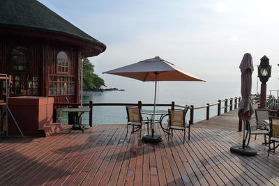 Chairs and tables on beach against sky