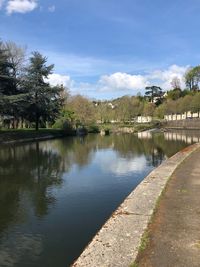 Scenic view of river by trees against sky